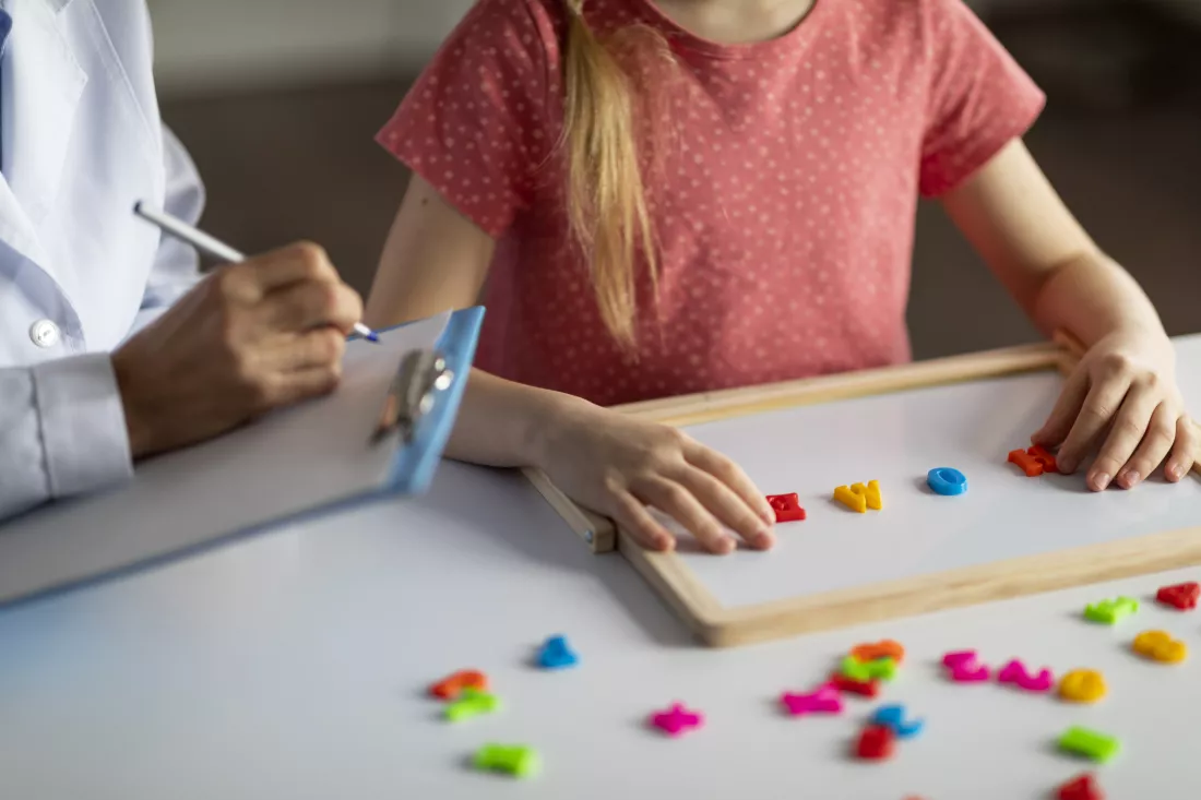 little-girl-exercising-with-alphabet-board-session-with-child-development-specialist